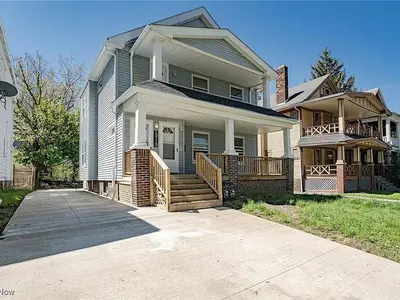 a large house with a porch and a porch at Family-owned 3BR in Larchmere Near Hospitals with Parking in Cleveland