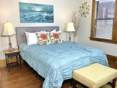 a bed in a bedroom with a blue comforter at 2 bedroom Loft apartment near downtown, Ohio city, Tremont! in Cleveland
