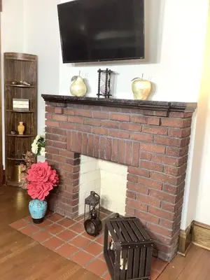 a brick fireplace with a television on top of it at 2 bedroom Loft apartment near downtown, Ohio city, Tremont! in Cleveland