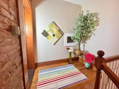 a hallway with a rug on the floor and a plant at 2 bedroom Loft apartment near downtown, Ohio city, Tremont! in Cleveland