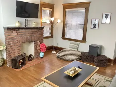 a living room with a brick fireplace and a tv at 2 bedroom Loft apartment near downtown, Ohio city, Tremont! in Cleveland