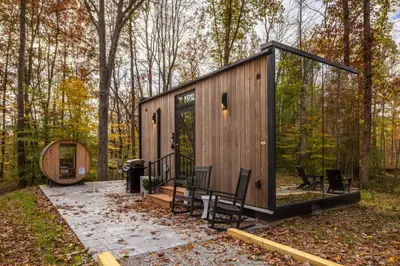a small cabin in the woods with a glass door at The Mirage Escape in New Plymouth