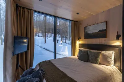 a bedroom with a bed and a large window at The Mirage Escape in New Plymouth