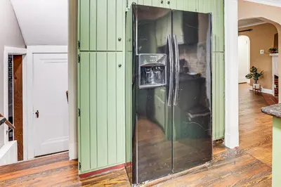 a glass refrigerator in a room with green walls at Inviting Family Home, 2 Mi to Eastwood Mall! in Niles