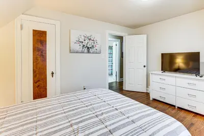 a white bedroom with a bed and a dresser at Inviting Family Home, 2 Mi to Eastwood Mall! in Niles