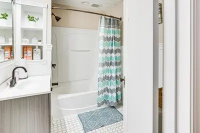 a bathroom with a shower and a white tub at Inviting Family Home, 2 Mi to Eastwood Mall! in Niles
