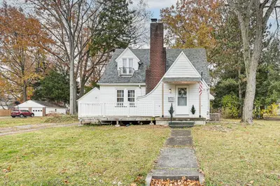 a white house with a chimney on a yard at Inviting Family Home, 2 Mi to Eastwood Mall! in Niles