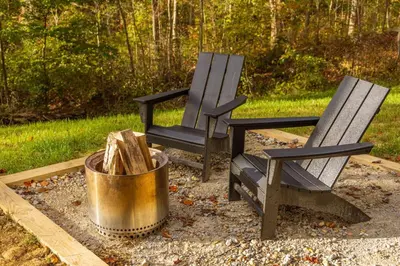 two chairs and a trash can in a yard at The Illusion Hideaway in New Plymouth