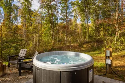 a hot tub in the woods with a bench at The Illusion Hideaway in New Plymouth