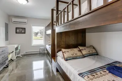 a bedroom with two bunk beds and a desk at Patio and Parking! Modern Bunkhouse Near Lake Erie in Oak Harbor