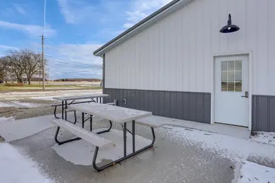 two picnic tables and a bench in front of a building at Patio and Parking! Modern Bunkhouse Near Lake Erie in Oak Harbor