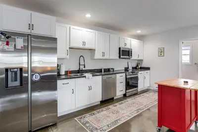 a kitchen with white cabinets and a stainless steel refrigerator at Patio and Parking! Modern Bunkhouse Near Lake Erie in Oak Harbor