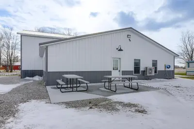 a building with two picnic tables in front of it at Patio and Parking! Modern Bunkhouse Near Lake Erie in Oak Harbor