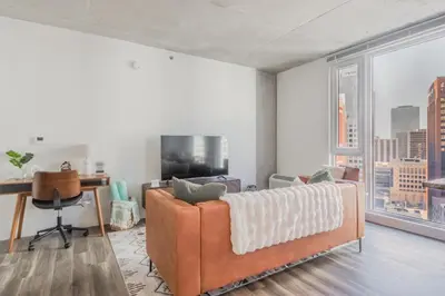 a living room with a couch and a large window at Skyline Sanctuary in Cleveland