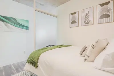 a white bedroom with a bed and a window at Skyline Sanctuary in Cleveland