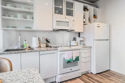a kitchen with white cabinets and a refrigerator at Skyline Sanctuary in Cleveland