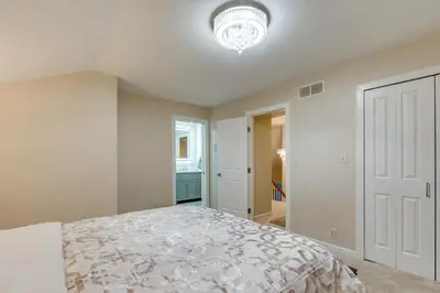 a bedroom with a bed and a chandelier at 7 Mi to Dtwn Toledo Spacious Family Home! in Perrysburg
