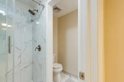a bathroom with a toilet and a glass shower at 7 Mi to Dtwn Toledo Spacious Family Home! in Perrysburg