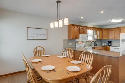 a dining room table with chairs and a kitchen at 1 mile to Downtown! Boat, Hike and Fish in Liberty