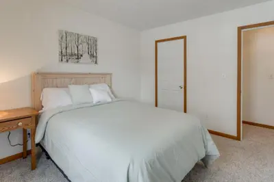 a bedroom with a bed and a table and a mirror at 1 mile to Downtown! Boat, Hike and Fish in Liberty