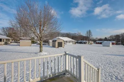 a snow covered yard with a white fence and a tree at 1 mile to Downtown! Boat, Hike and Fish in Liberty