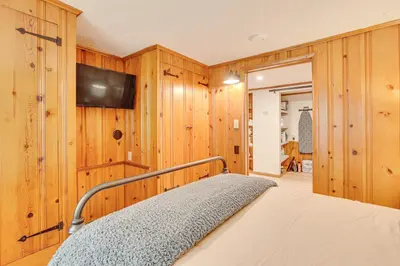 a bedroom with wooden walls and a bed with a television at Trails, Wine and Events! Cuyahoga Falls Retreat in Cuyahoga Falls