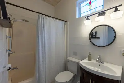 a bathroom with a toilet and a sink and a mirror at Cozy Spring Night HotTub Firepit PetFriendly Patio in McArthur