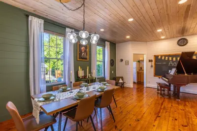 a dining room with a table and a piano at Cozy Spring Night HotTub Firepit PetFriendly Patio in McArthur