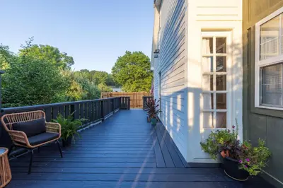 a deck with a chair and a house at Cozy Spring Night HotTub Firepit PetFriendly Patio in McArthur