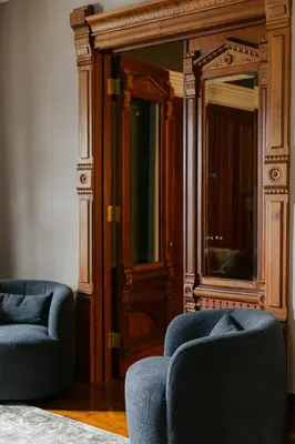 a room with two blue chairs and a mirror at 1868 Historic Victorian, 4Bed-4Bath, Downtown Loudonville, Sleeps 10 in Loudonville