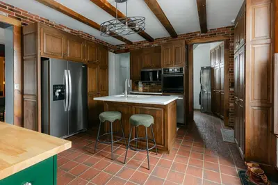 a kitchen with a refrigerator and two bar stools at 1868 Historic Victorian, 4Bed-4Bath, Downtown Loudonville, Sleeps 10 in Loudonville