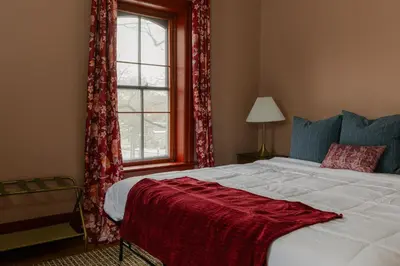 a bedroom with a bed with a red blanket on it at 1868 Historic Victorian, 4Bed-4Bath, Downtown Loudonville, Sleeps 10 in Loudonville