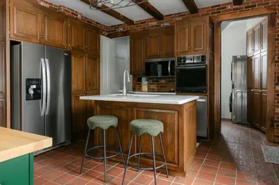 a kitchen with a refrigerator and two bar stools at 1868 Historic Victorian, 4Bed-4Bath, Downtown Loudonville, Sleeps 10 in Loudonville