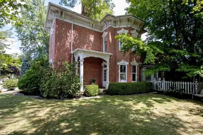 a large red brick house with a white fence at 1868 Historic Victorian, 4Bed-4Bath, Downtown Loudonville, Sleeps 10 in Loudonville