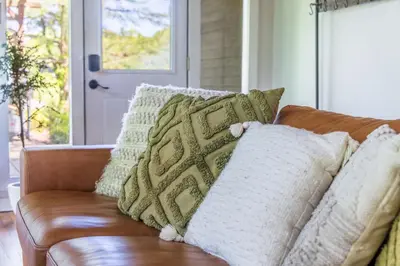 a couch with pillows on it in a living room at Lakefront Vibes Lake Access•Hot Tub•Firepit•Pets in Rockbridge
