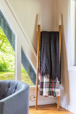 a blanket on a chair next to a window at Lakefront Vibes Lake Access•Hot Tub•Firepit•Pets in Rockbridge