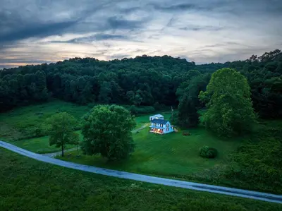 an aerial view of a blue house in the middle of a field at Nature-Quiet Retreat • Firepit BBQ • PetFriendly in McArthur