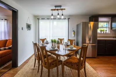 a kitchen and dining room with a table and a refrigerator at Nature-Quiet Retreat • Firepit BBQ • PetFriendly in McArthur