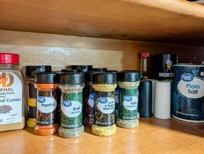 a shelf with different types of spices in jars at Home to Unwind in Columbus