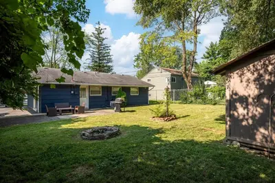 a yard with a blue house with a fire pit at Home to Unwind in Columbus