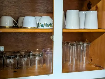 a cabinet filled with glass mason jars and cups at Home to Unwind in Columbus