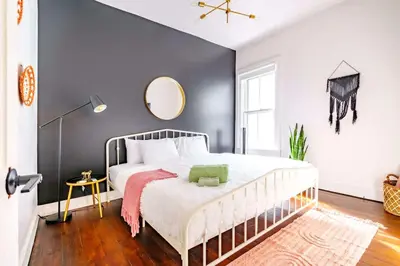 a bedroom with a large bed with a mirror on the wall at Yoctangee House by Jungle House in Chillicothe