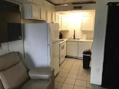 a small kitchen with a white refrigerator and a couch at Castle Apartments in Marion