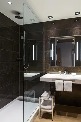 a bathroom with a shower and a sink and a mirror at AC Hotel Cincinnati at Liberty Center in West Chester