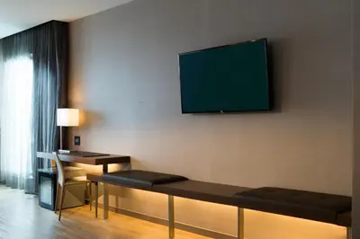 a living room with a tv on a wall at AC Hotel Cincinnati at Liberty Center in West Chester