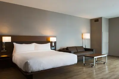a hotel room with a bed and a couch at AC Hotel Cincinnati at Liberty Center in West Chester