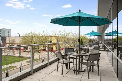 a patio with tables and chairs and an umbrella at AC Hotel Cincinnati at Liberty Center in West Chester