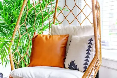 a rattan chair with pillows and a plant at Jungle Fever by Jungle House Walk to High Street Near Convention Center OSU & Nationwide Arena Downtown & Short North 5 800 Reviews Private Parking in Columbus