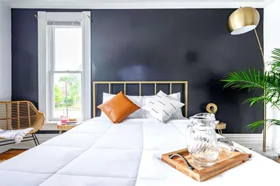 a bedroom with a large white bed with a wooden tray on it at Jungle Fever by Jungle House Walk to High Street Near Convention Center OSU & Nationwide Arena Downtown & Short North 5 800 Reviews Private Parking in Columbus