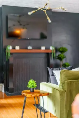 a living room with a couch and a table with a plant at Bamboo Bungalow by Jungle House Near Convention Center OSU & Nationwide Arena Walk to High Street Downtown & Short North 5 800 Reviews Private Parking in Columbus